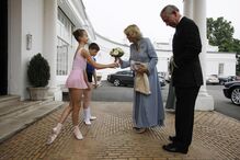 O príncipe Carlos e a sua esposa, Camilla, são recebidos por duas bailarinas à chegada a uma gala no Royal Ballet School, em Londres. (Stefan Wermuth / Reuters)