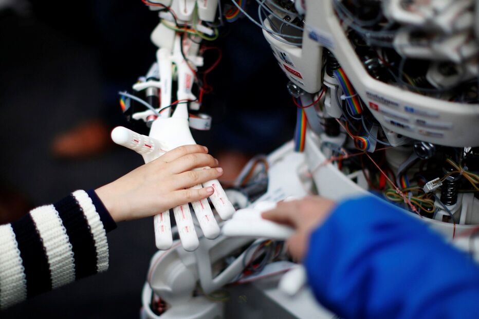 Uma criança cumprimenta um robô humanoide batizado com o nome de ‘Roboy’, que foi apresentado ontem durante uma exposição que marcou o 25.º aniversário do Laboratório de Inteligência Artificial da Universidade de Zurique, na Suíça.