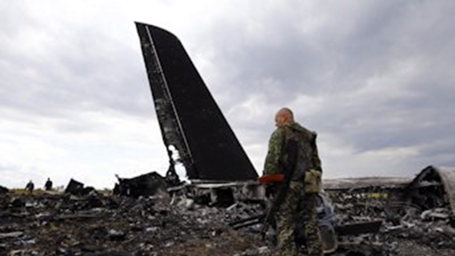 Separatistas pró-russos caminham junto do local onde o avião abatido se despenhou, em Luhansk