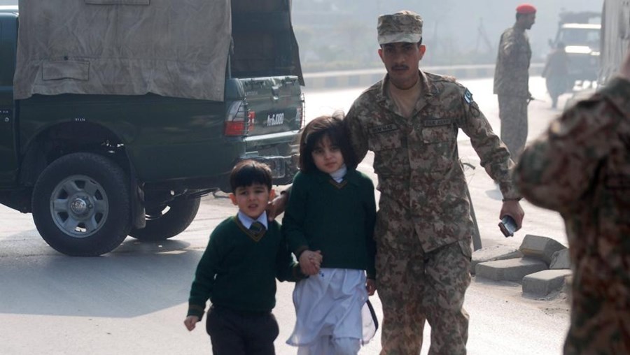 Soldado ajuda crianças sobreviventes a sair da escola bombardeada