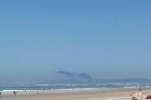 Imagens da coluna de fumo resultante do acidente, vista da Costa da Caparica