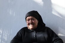 Maria do Anjos, sobrinha da vidente Lúcia, sentada à porta de casa, em frente àquela que foi a casa dos pais de Lúcia, em Aljustrel