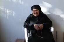 Maria do Anjos, sobrinha da vidente Lúcia, sentada à porta de casa, em frente àquela que foi a casa dos pais de Lúcia, em Aljustrel
