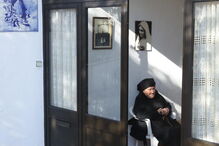 Maria do Anjos, sobrinha da vidente Lúcia, sentada à porta de casa, em frente àquela que foi a casa dos pais de Lúcia, em Aljustrel