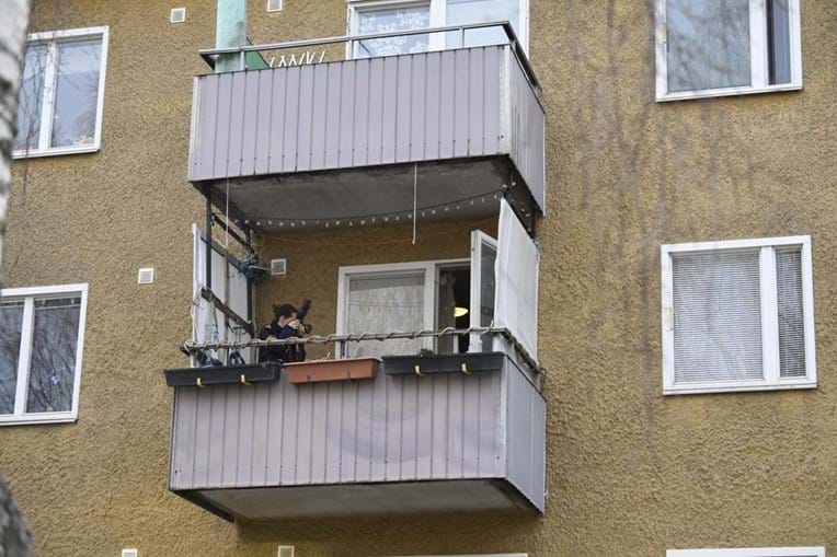 Agente da polícia fotografa a casa de um dos suspeitos, nos arredores de Estocolmo