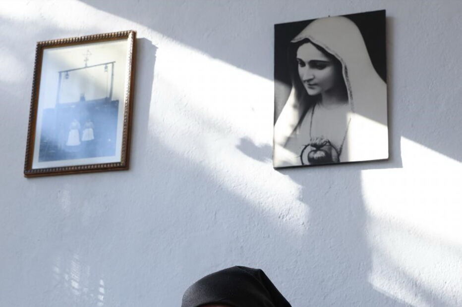 Maria do Anjos, sobrinha da vidente Lúcia, sentada à porta de casa, em frente àquela que foi a casa dos pais de Lúcia, em Aljustrel