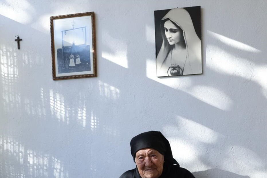 Maria do Anjos, sobrinha da vidente Lúcia, sentada à porta de casa, em frente àquela que foi a casa dos pais de Lúcia, em Aljustrel