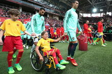 Cristiano Ronaldo entra em campo de mãos dadas com menina em cadeira de rodas