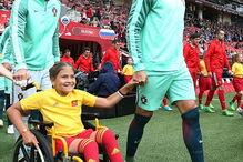 Cristiano Ronaldo entra em campo de mãos dadas com menina em cadeira de rodas