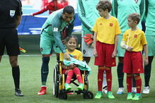 Cristiano Ronaldo entra em campo de mãos dadas com menina em cadeira de rodas