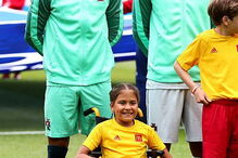 Cristiano Ronaldo entra em campo de mãos dadas com menina em cadeira de rodas