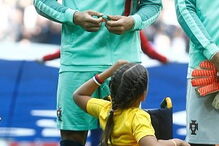 Cristiano Ronaldo entra em campo de mãos dadas com menina em cadeira de rodas