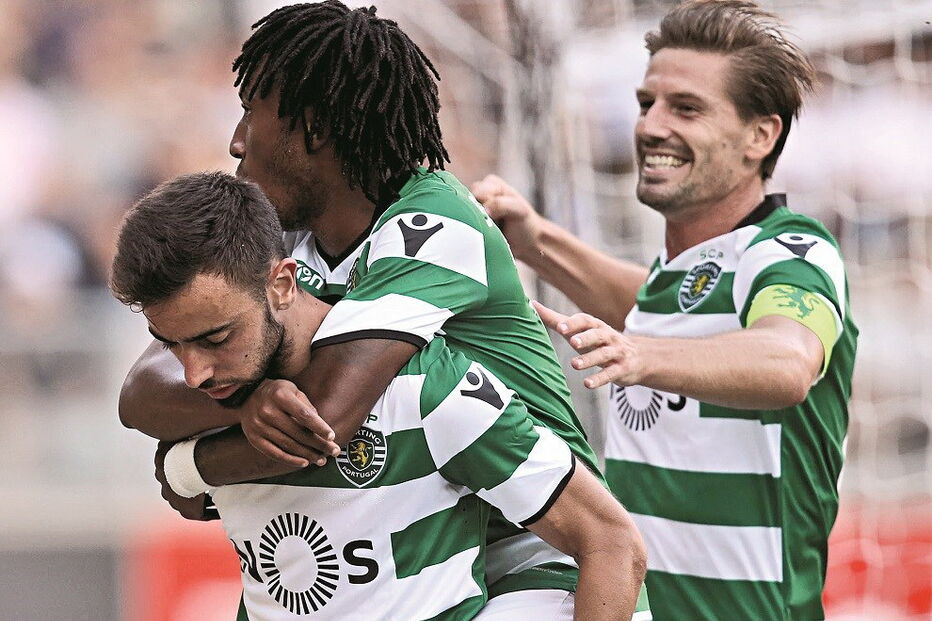 Bruno Fernandes (esq.) é saudado por Gelson Martins e Adrien Silva após o primeiro golo da partida 