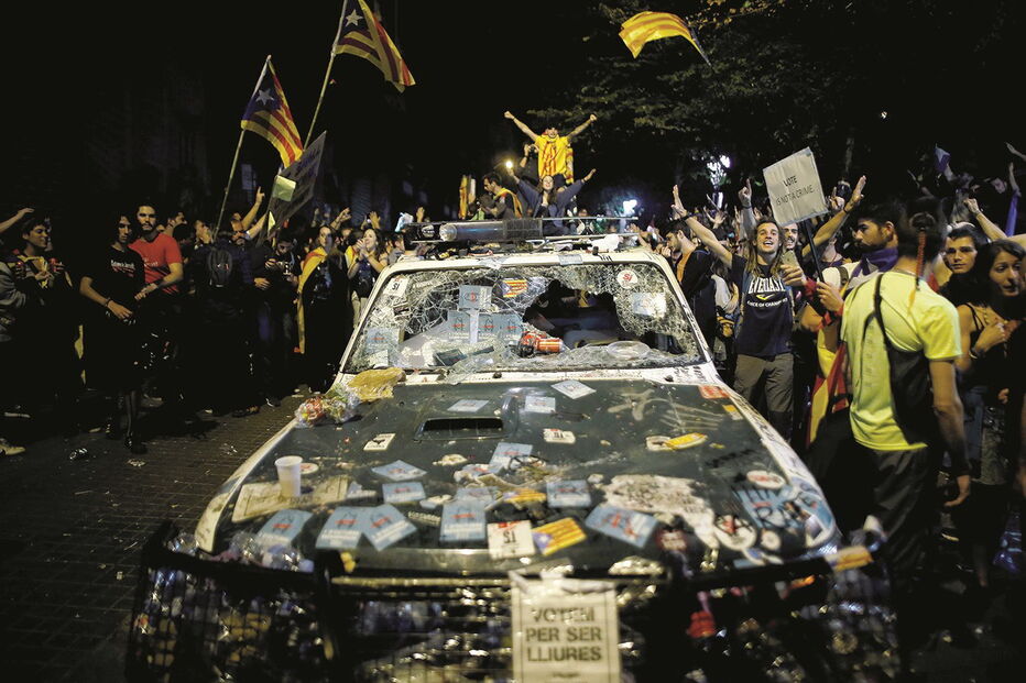 Apoiantes da independência cercaram agentes da Guardia Civil e vandalizaram viaturas policiais em Barcelona