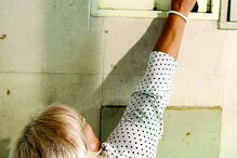 Maria do Carmo Francisco mostra o disjuntor danificado no quadro elétrico e critica as constantes avarias que a impedem de sair de casa  