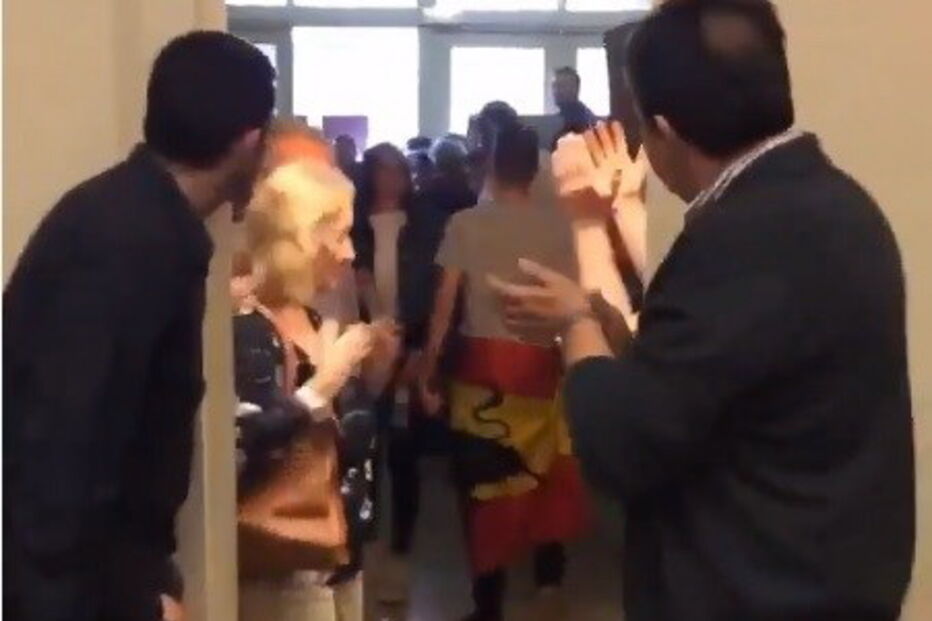 Jovem aplaudido ao votar com bandeira espanhola à cintura
