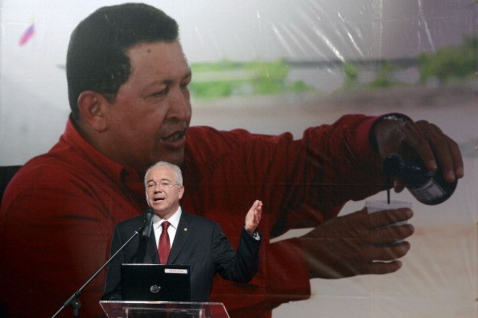 Rafael Ramirez, ex-ministro do Petróleo da Venezuela, discursa com imagem Chavéz em fundo