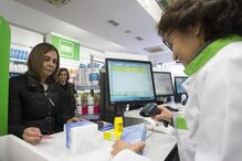 A bastonária da Ordem dos Farmacêuticos seleciona medicamentos durante a campanha