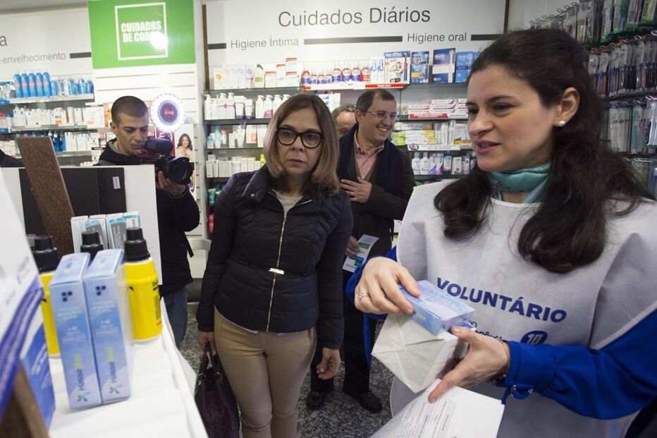 A bastonária da Ordem dos Farmacêuticos seleciona medicamentos durante a campanha