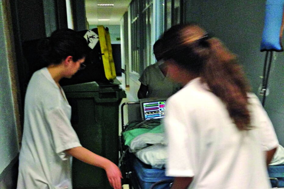 Auxiliares tentam passar com criança junto a contentor do lixo