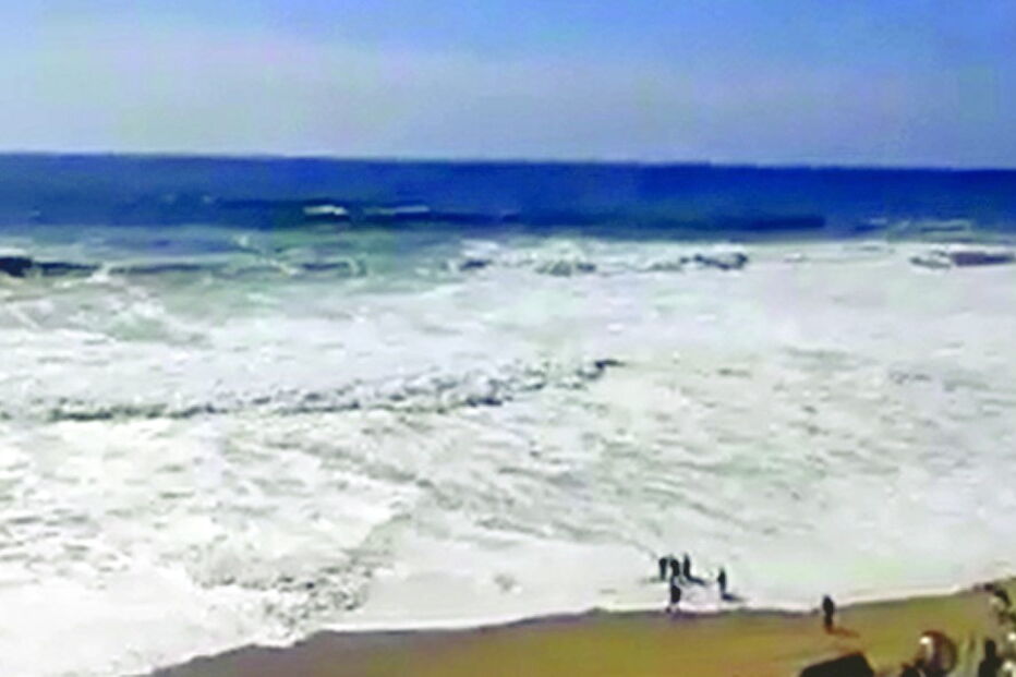 Momento em que corpo é devolvido pelo mar e recuperado por elementos da Estação Salva Vidas e pescadores