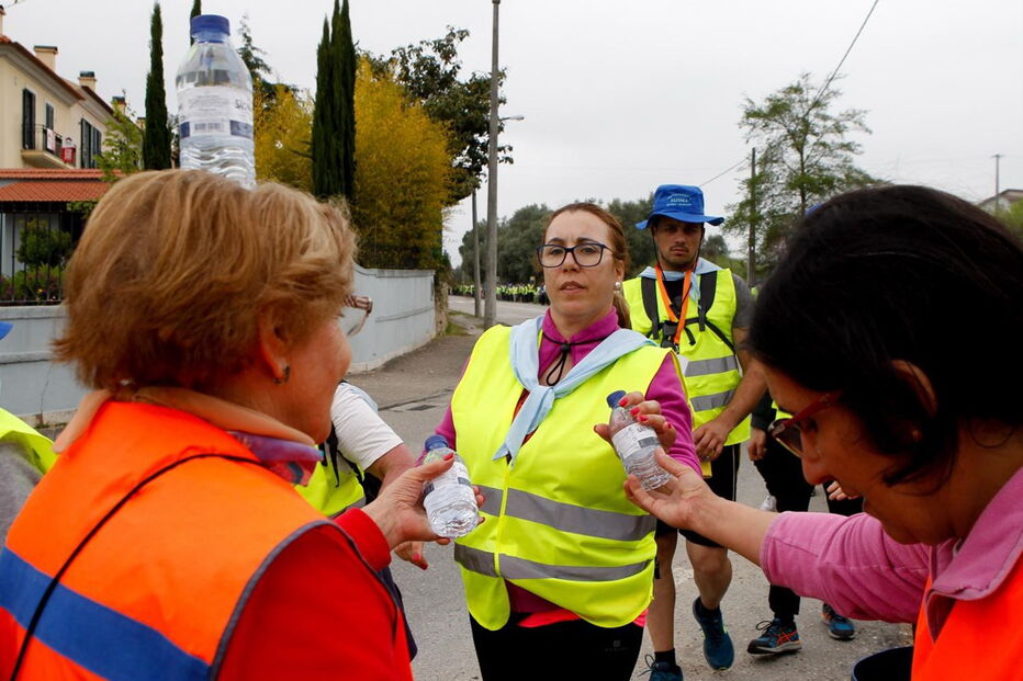 Voluntária distribui garrafas de água por um grupo de peregrinos proveniente de Felgueiras durante a passagem por Coimbra