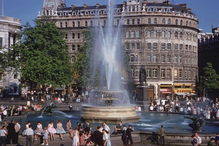 Pessoas sentadas em volta da fonte de Trafalgar Square em meados dos anos 50