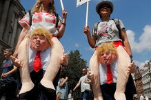 Duas manifestantes exibem fatos alusivos à visita de Trump