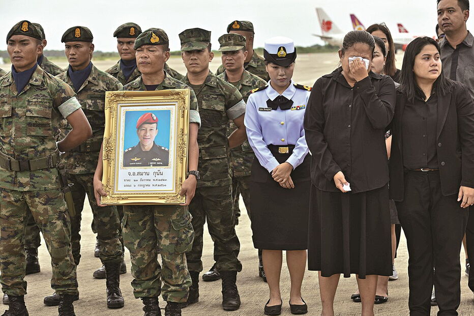 Guarda exibe a fotografia do ex-fuzileiro morto durante uma homenagem junto de membros da família