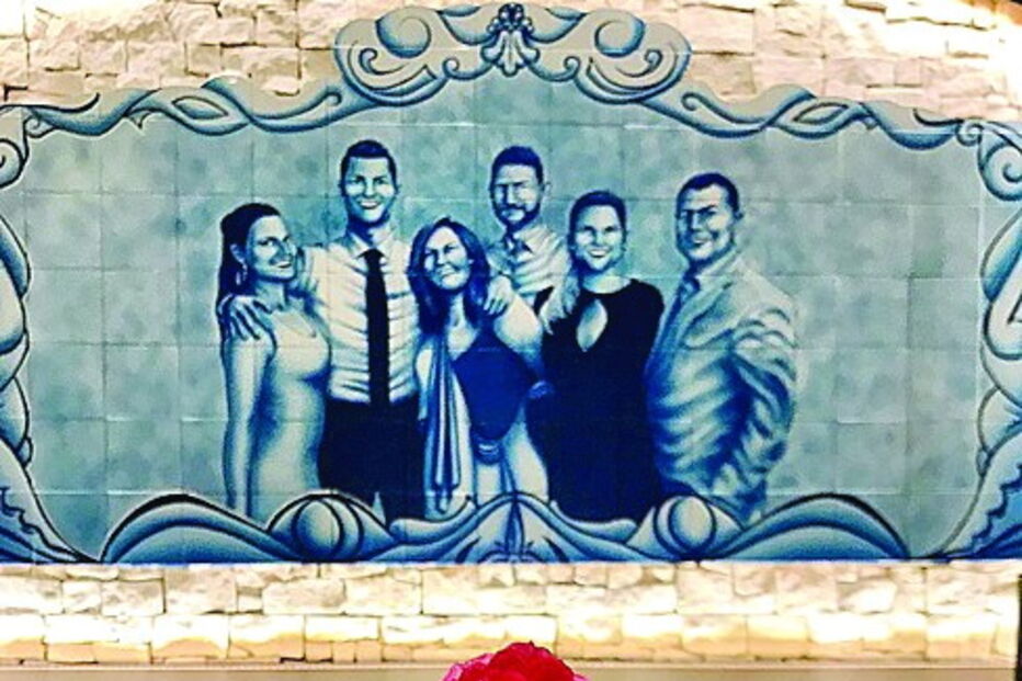 O famoso Bacalhau CR7 e, atrás, um mural que retrata a família Aveiro