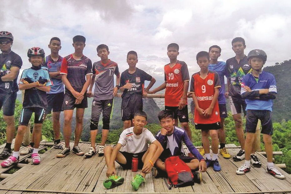 O treinador (à esquerda) e os 12 ‘Javalis Selvagens’  antes de entrarem na gruta