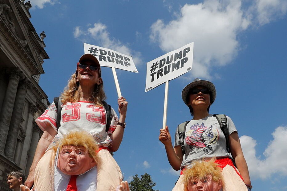Duas manifestantes exibem fatos alusivos à visita de Trump