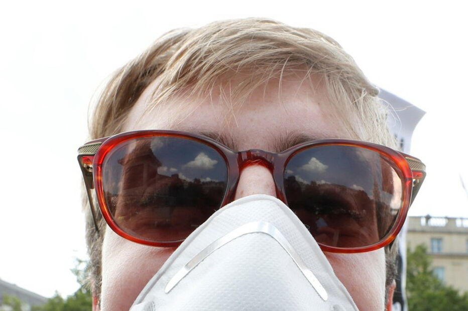 Uma manifestante com uma máscara alusiva a Trump