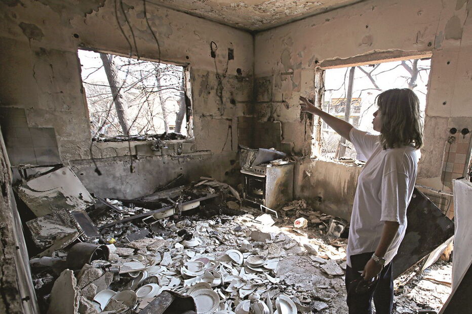 Uma moradora de Mati observa os estragos causados pelo fogo na sua residência