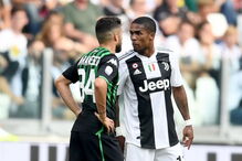 Douglas Costa cospe em adversário durante jogo da Juventus