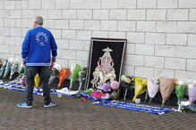 Adeptos do Leicester City deixam flores junto ao estáido onde helicóptero caiu