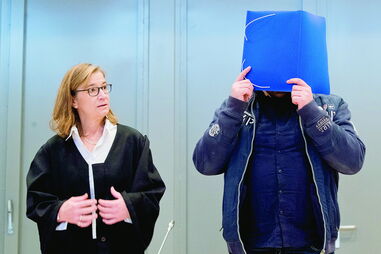 Niels Högel, o assassino confesso, compareceu em tribunal com o rosto escondido por uma capa de plástico  