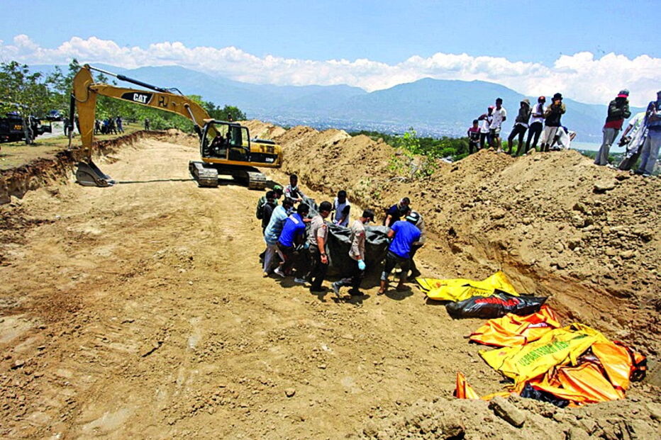 Vítimas do sismo e tsunami estão a ser sepultadas numa vala comum gigante   