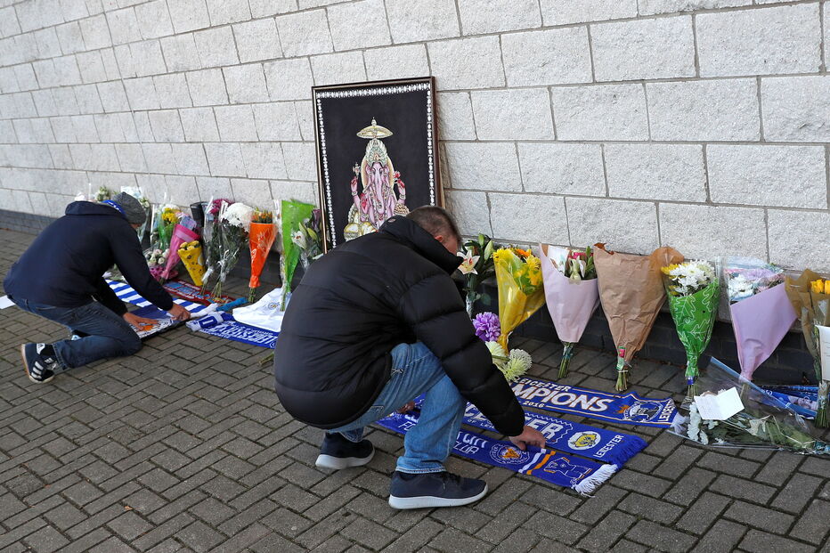 Adeptos do Leicester City deixam flores junto ao estáido onde helicóptero caiu
