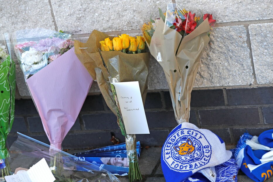 Adeptos do Leicester City deixam flores junto ao estáido onde helicóptero caiu