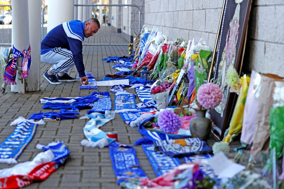 Adeptos do Leicester City deixam flores junto ao estáido onde helicóptero caiu