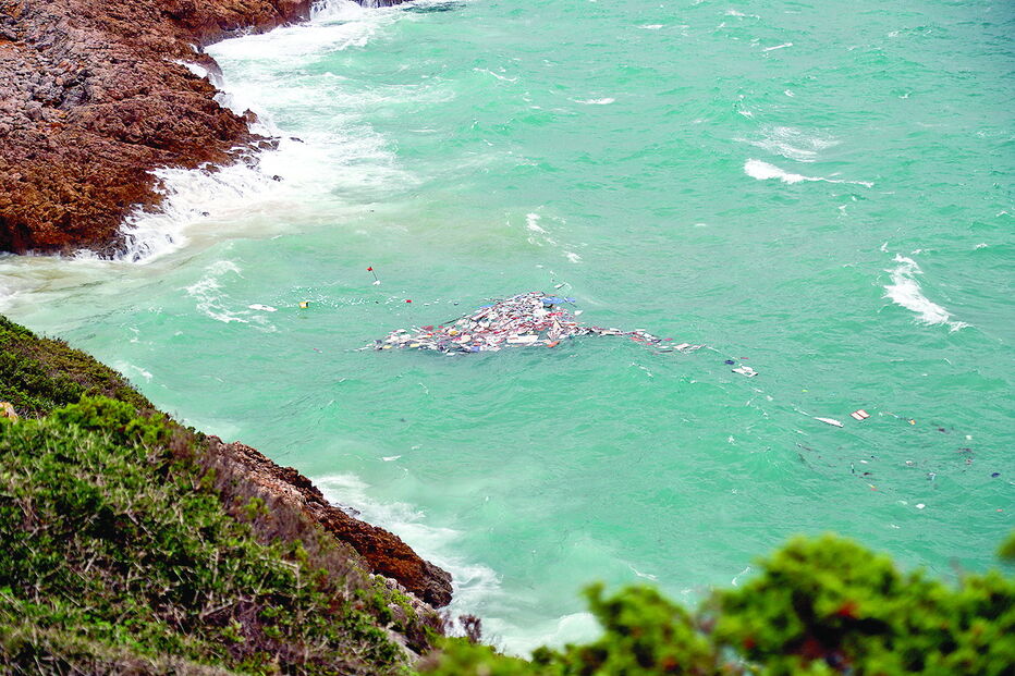 Destroços da embarcação ficaram espalhados pela água junto à costa  