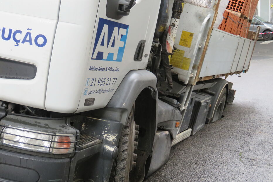 Estrada cede em Lisboa e camião com material de construção fica preso 