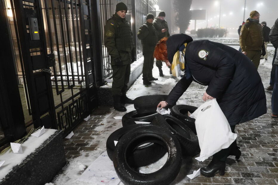 Homem coloca vários barcos de papel em frente à embaixada russa em Kiev, na Ucrânia