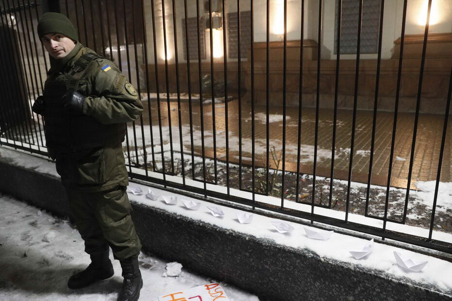 Homem coloca vários barcos de papel em frente à embaixada russa em Kiev, na Ucrânia