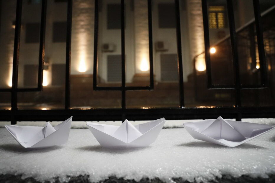 Homem coloca vários barcos de papel em frente à embaixada russa em Kiev, na Ucrânia