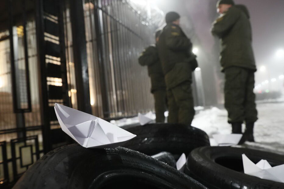 Homem coloca vários barcos de papel em frente à embaixada russa em Kiev, na Ucrânia