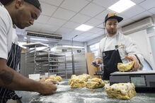 O proprietário do estabelecimento auxilia na confeção do Bolo Rei