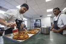 O proprietário do estabelecimento auxilia na confeção do Bolo Rei