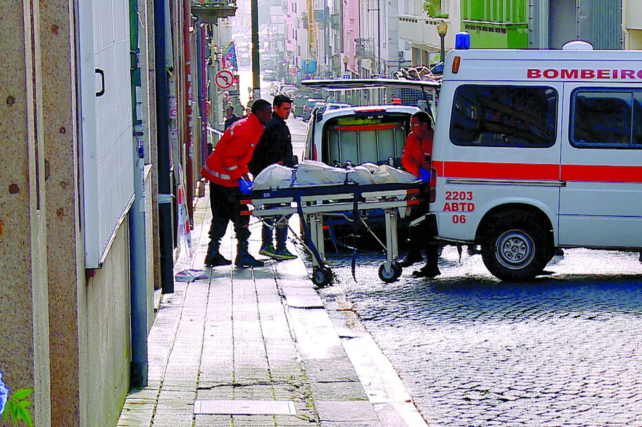 Corpo da vítima a ser retirado da casa que ardeu na rua da Alegria
